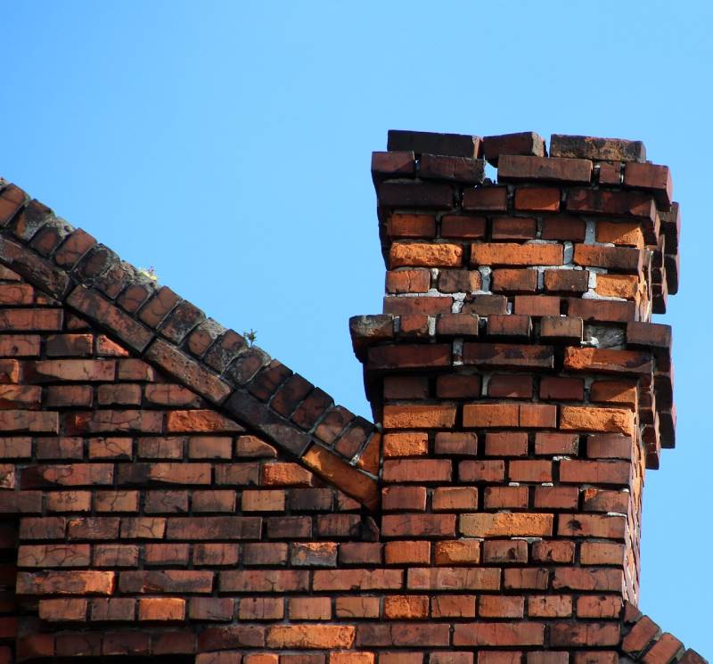 Damaged chimney on an Dexter home showing cracks and missing mortar